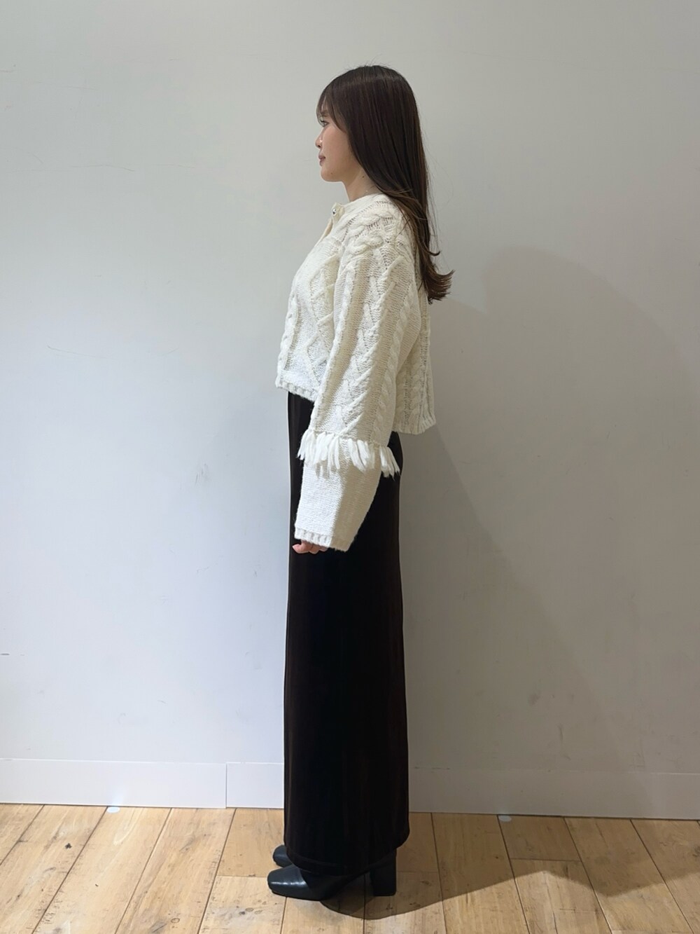 ホワイト系のカーディガン/ボレロ、ブラウン系のスカートを着用したレディースの秋コーディネートの2枚目の写真