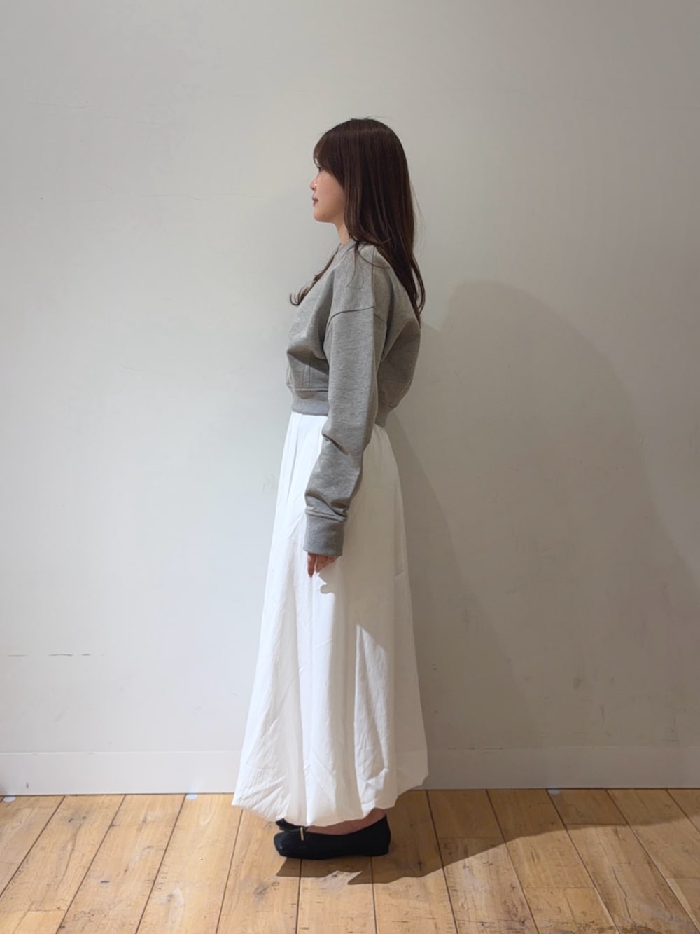 ホワイト系のスカート、ブラック系のその他シューズを着用したレディースの春コーディネートの2枚目の写真