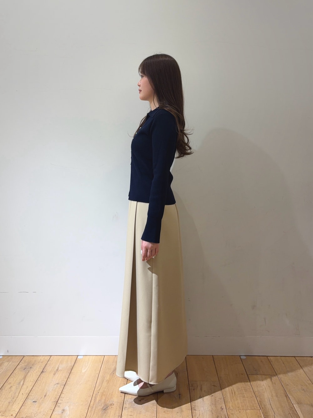 ブルー系のカーディガン/ボレロ、ベージュ系のスカート、ホワイト系のパンプスを着用したレディースの冬コーディネートの2枚目の写真