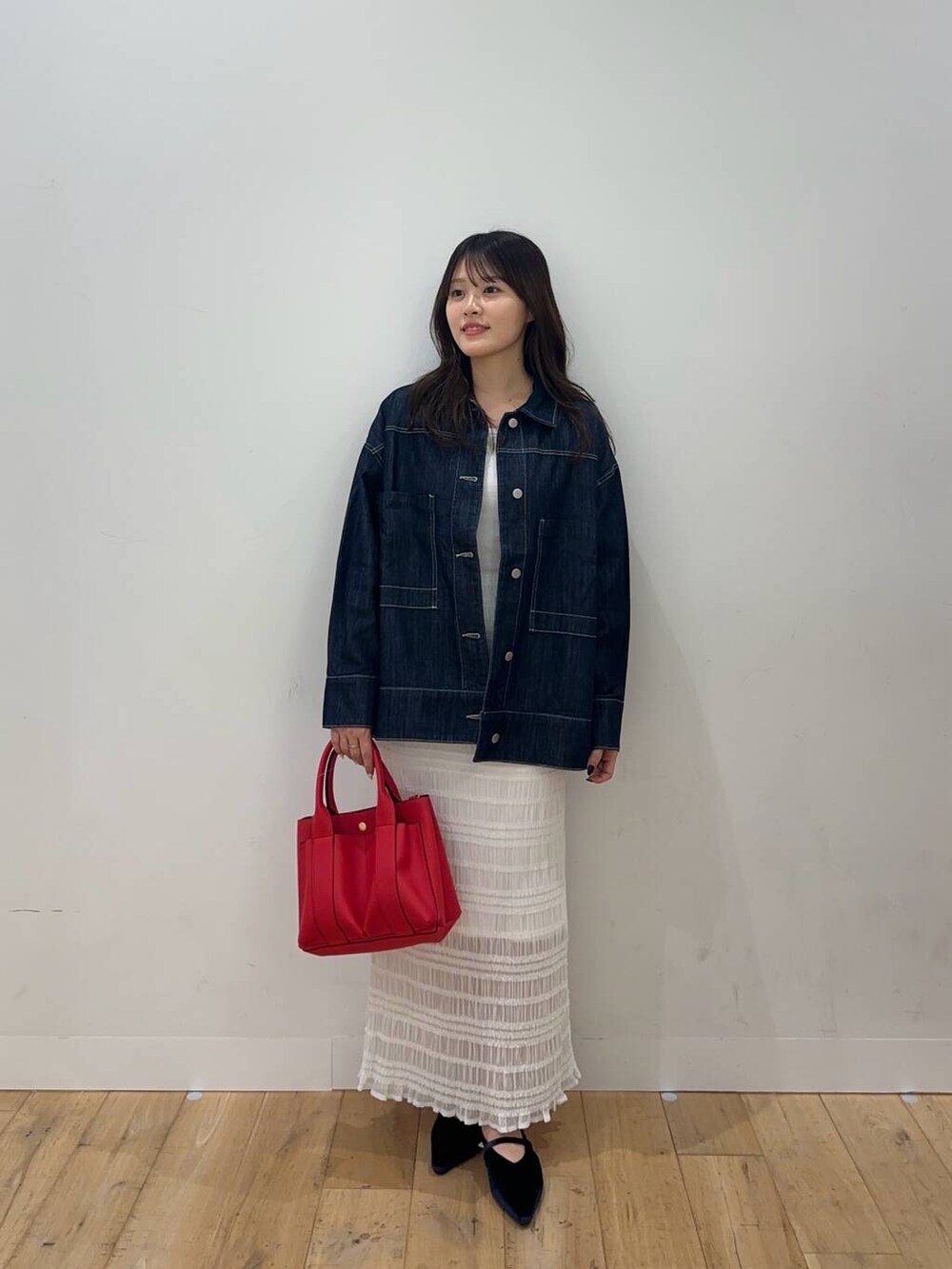 ホワイト系のTシャツ/カットソー、ホワイト系のスカート、ブルー系のパンプスを着用したレディースの秋コーディネートの2枚目の写真