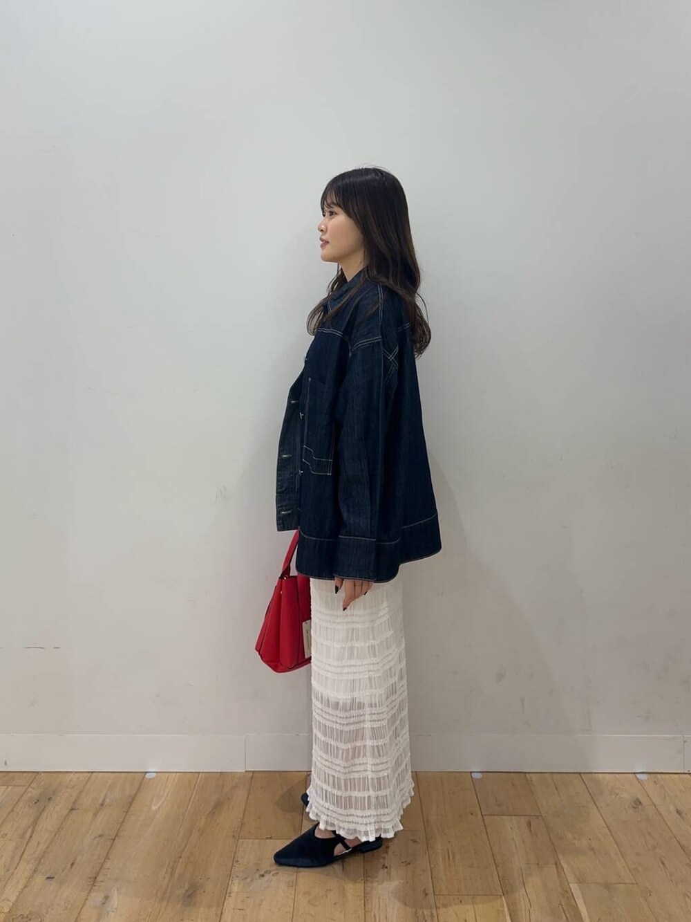 ホワイト系のTシャツ/カットソー、ホワイト系のスカート、ブルー系のパンプスを着用したレディースの秋コーディネートの3枚目の写真