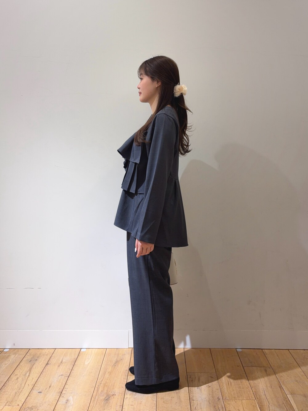 グレー系のスーツセット、ブラック系のハンドバッグを着用したレディースの冬コーディネートの3枚目の写真