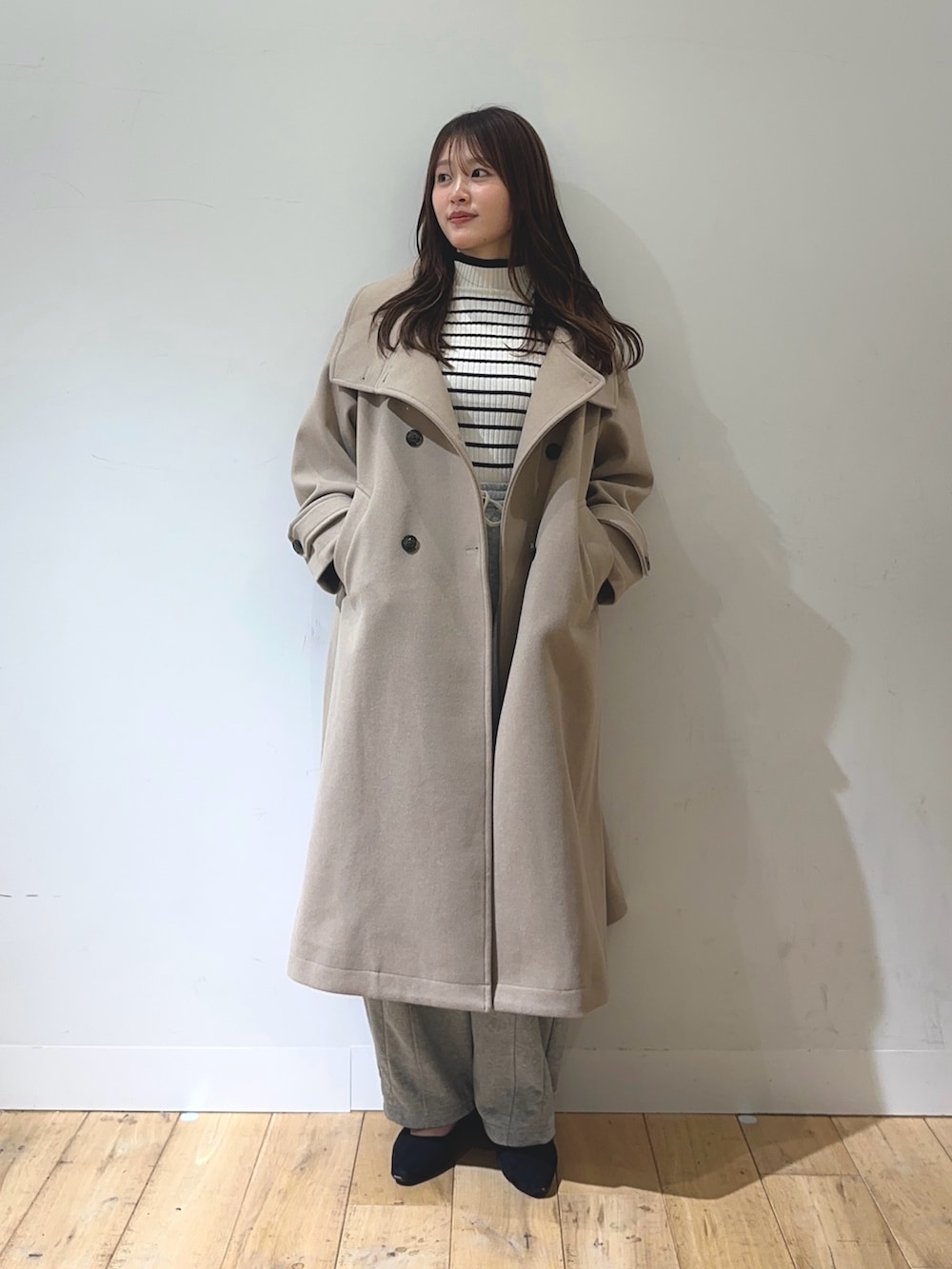 ベージュ系のその他アウター、グレー系のその他パンツ、ホワイト系のニット/セーターを着用したレディースの秋コーディネートの2枚目の写真