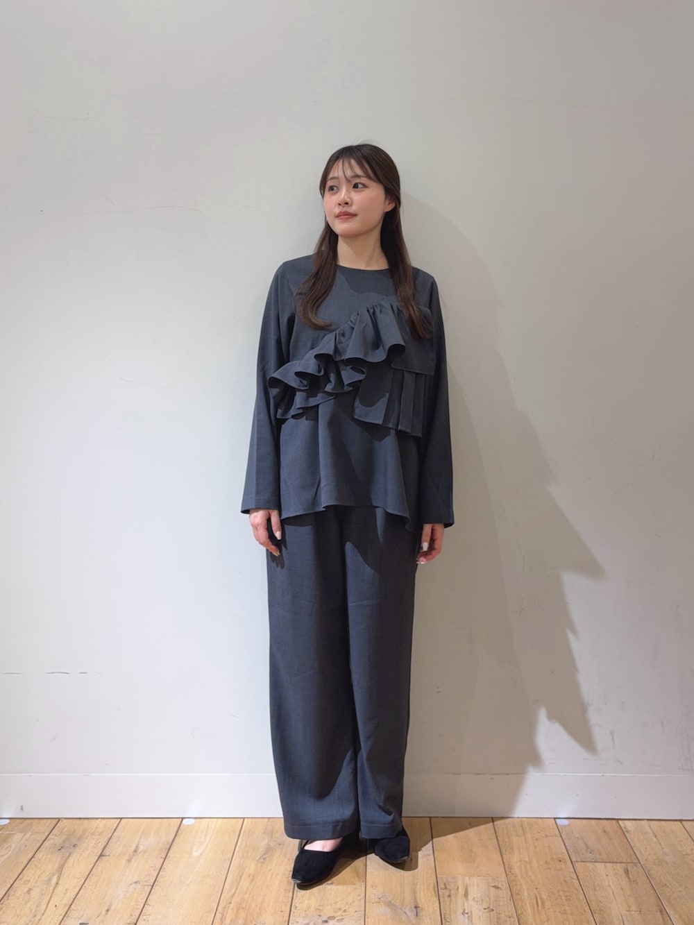 グレー系のスーツセット、ブラック系のハンドバッグを着用したレディースの冬コーディネートの2枚目の写真