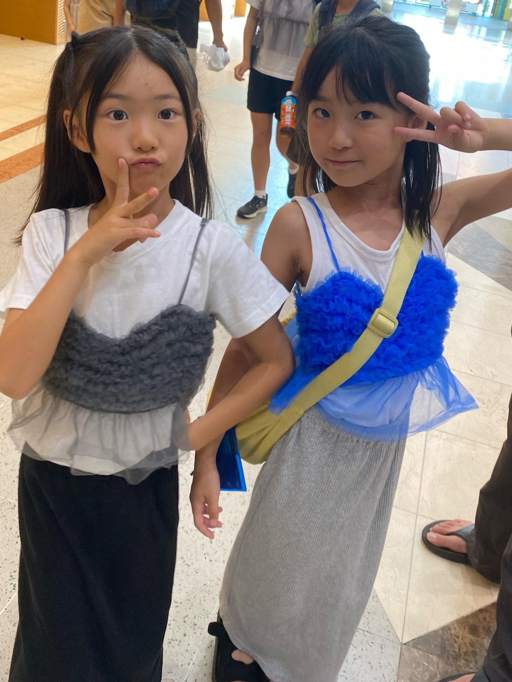 グレー系のスカート、ブラック系のキャミソール、ブルー系のキャミソールを着用したキッズの秋コーディネートの3枚目の写真