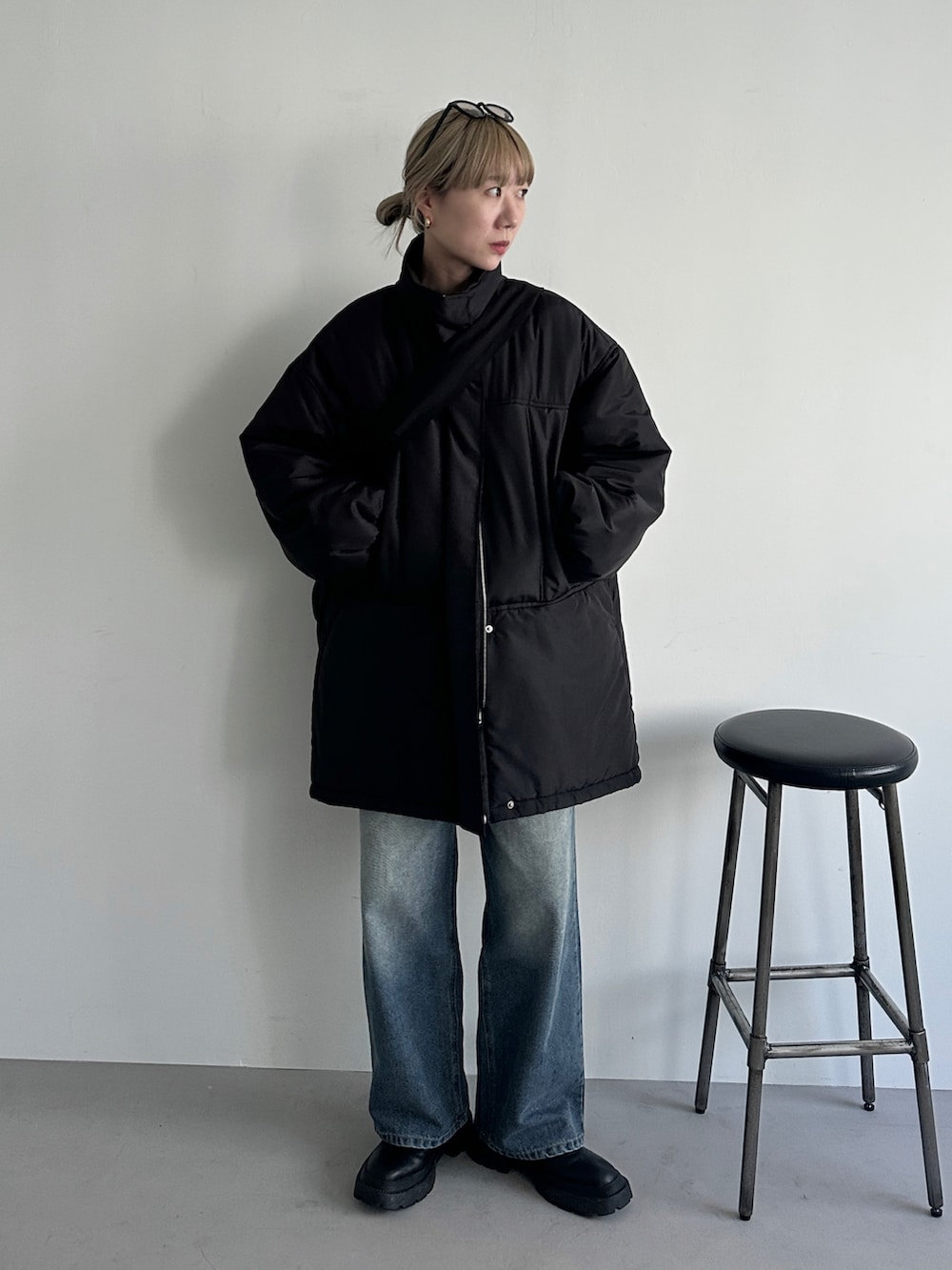 ブラック系のその他アウター、ブルー系のデニムパンツ、ブラック系のショルダーバッグを着用したレディースの冬コーディネートの2枚目の写真