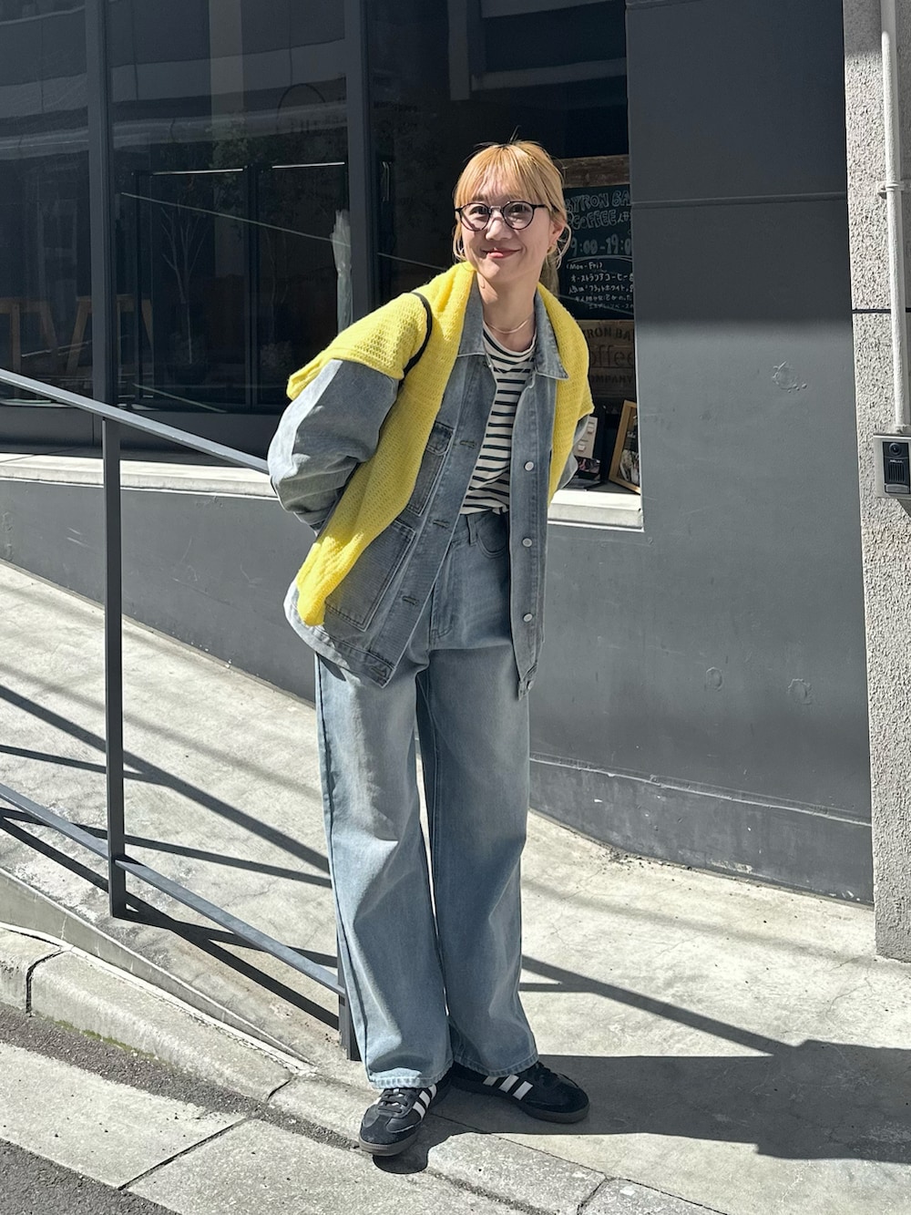 ブルー系のデニムジャケット、ブルー系のデニムパンツ、イエロー系のニット/セーターを着用したレディースの春コーディネートの2枚目の写真