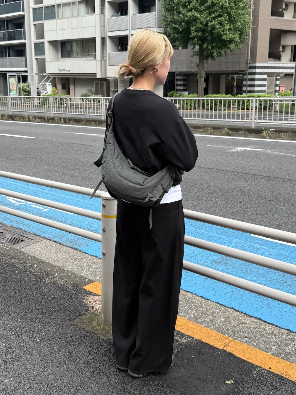 ブラック系のスウェット、ホワイト系のTシャツ/カットソー、ブラック系のスラックスを着用したレディースの秋コーディネートの2枚目の写真