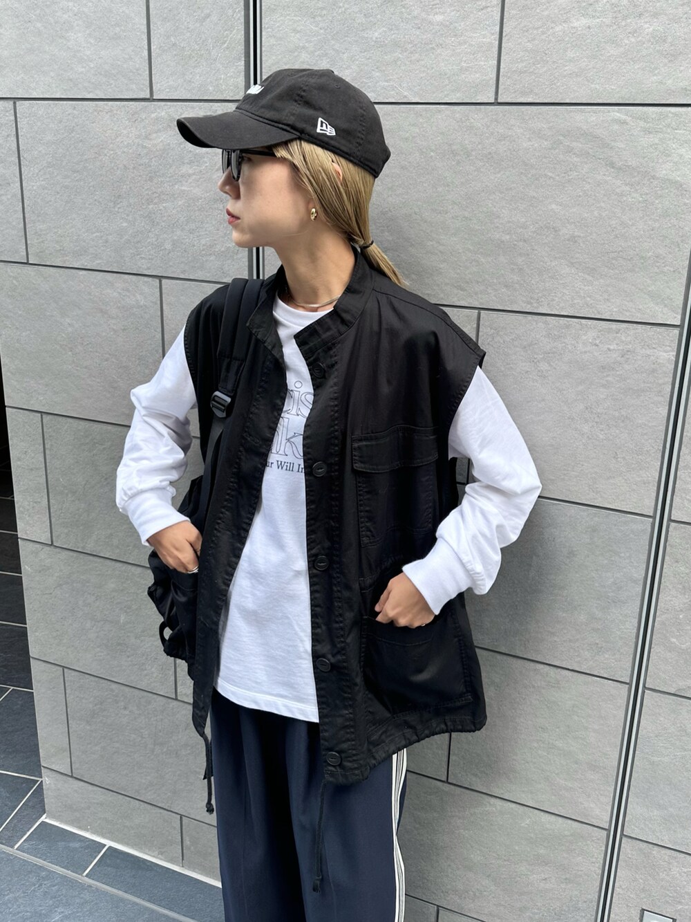 ホワイト系のスウェット、ブラック系のベスト、ブルー系のスラックスを着用したレディースの秋コーディネートの3枚目の写真