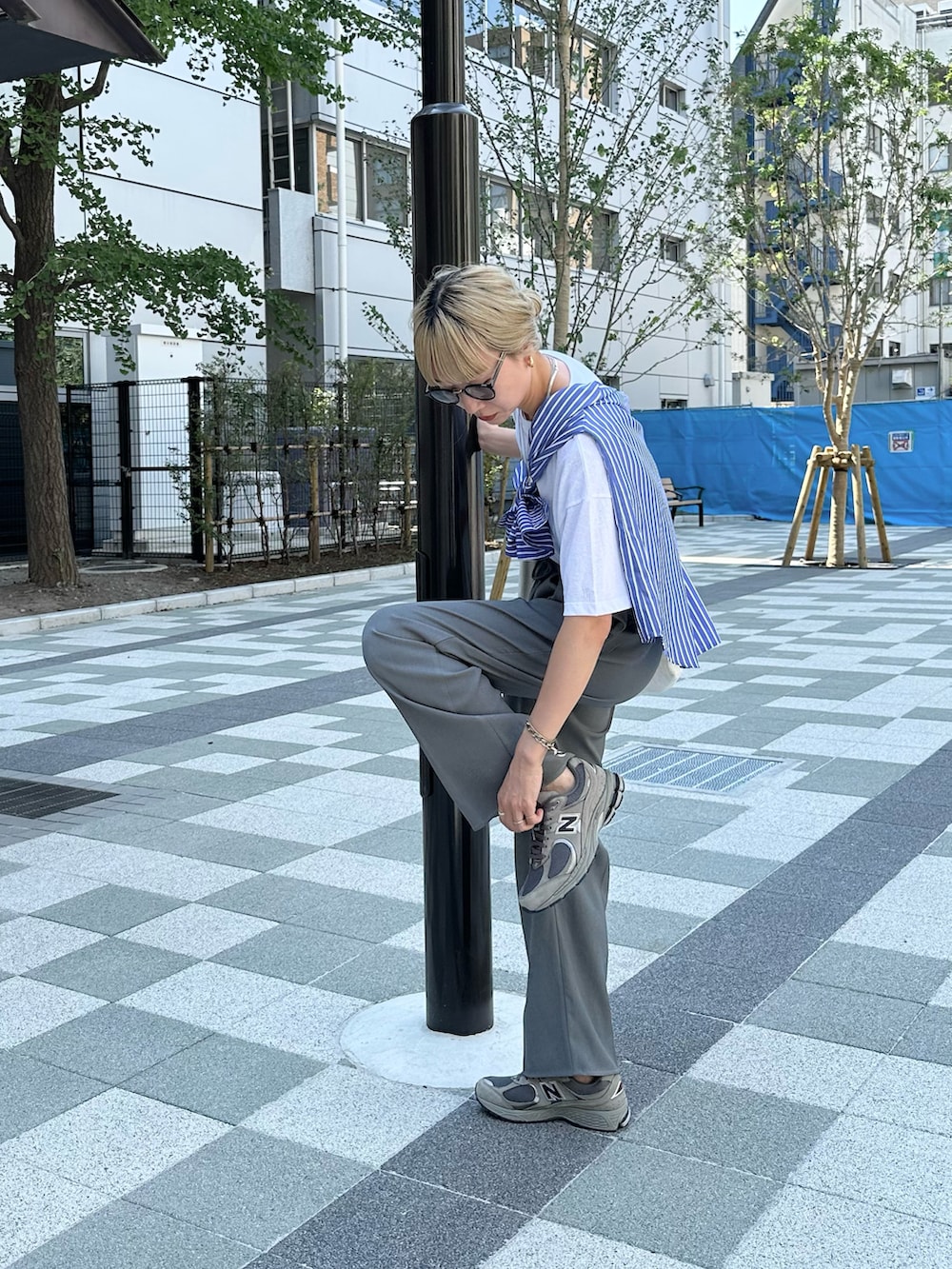 ホワイト系のTシャツ/カットソー、ブルー系のシャツ/ブラウス、グレー系のスラックスを着用したレディースの夏コーディネートの2枚目の写真