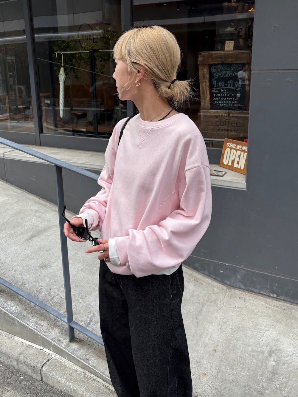 ピンク系のスウェット、ホワイト系のTシャツ/カットソー、ブラック系のデニムパンツを着用したレディースの秋コーディネートの5枚目の写真