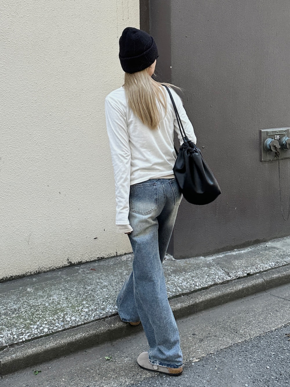 ホワイト系のTシャツ/カットソー、ブルー系のデニムパンツ、ブラック系のショルダーバッグを着用したレディースの春コーディネートの2枚目の写真