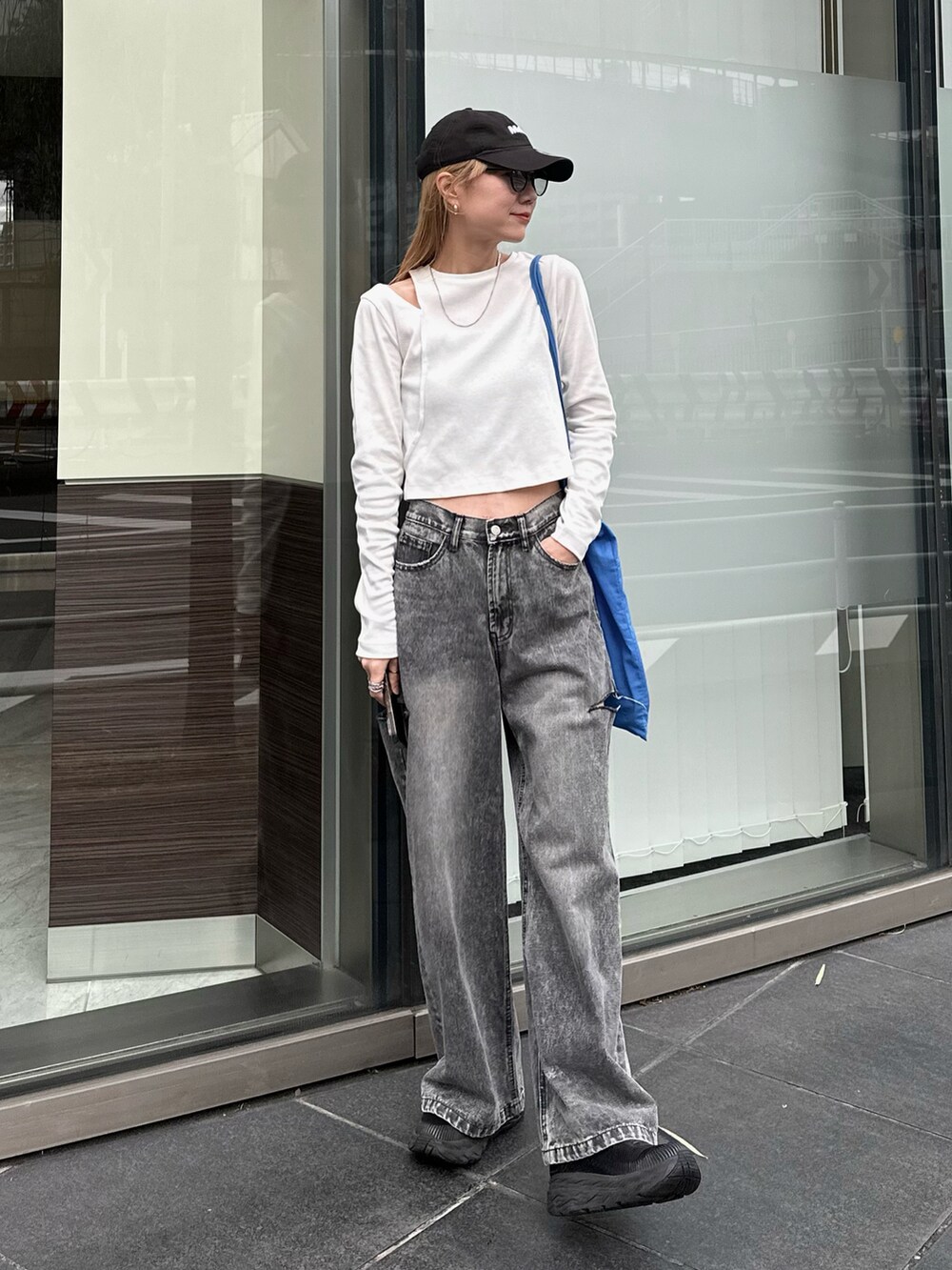 ホワイト系のTシャツ/カットソー、ブラック系のデニムパンツ、ブルー系のトートバッグを着用したレディースの春コーディネートの2枚目の写真