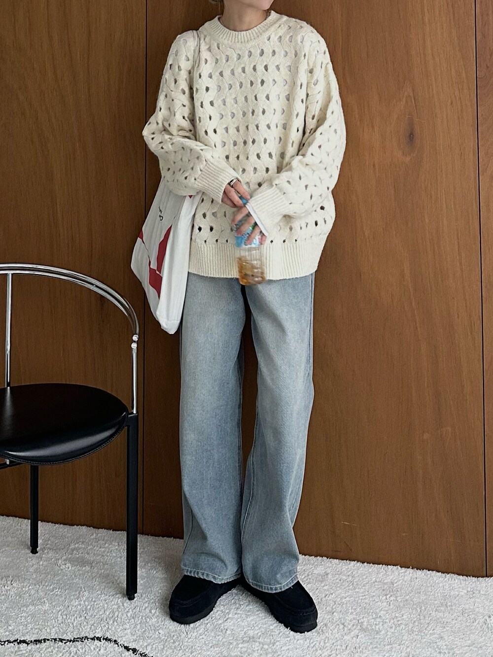 ホワイト系のニット/セーター、ホワイト系のTシャツ/カットソー、ブルー系のデニムパンツを着用したレディースの秋コーディネートの3枚目の写真