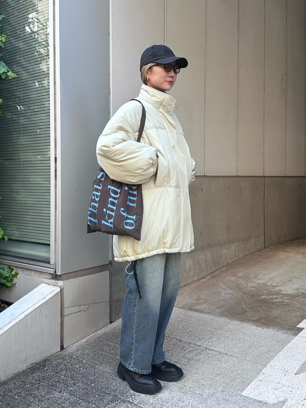 ベージュ系のその他アウター、ブルー系のデニムパンツ、ブラウン系のトートバッグを着用したレディースの冬コーディネートの2枚目の写真