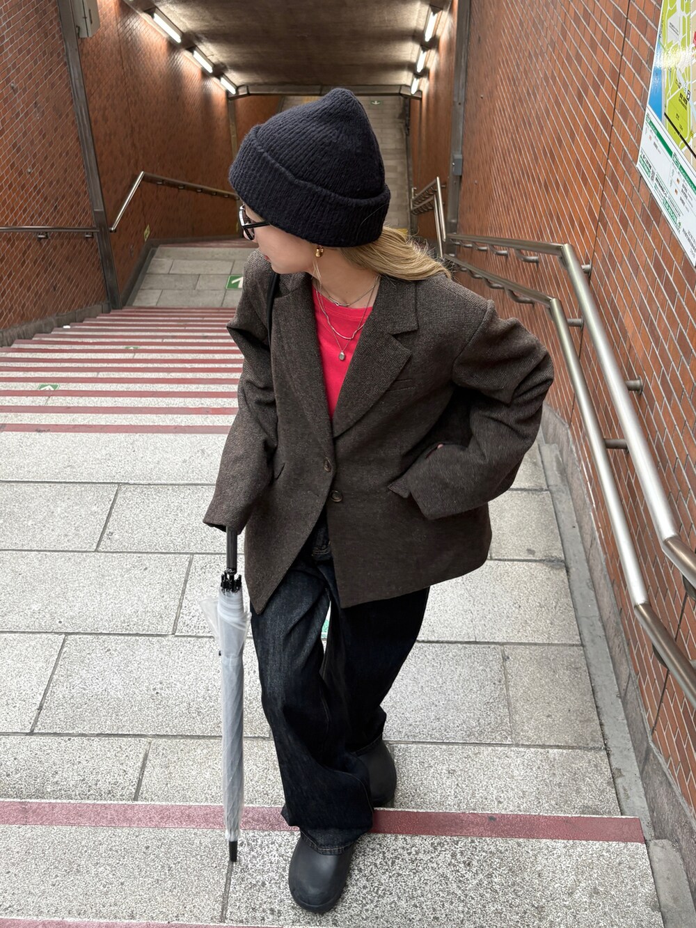 ブラウン系のテーラードジャケット、レッド系のTシャツ/カットソー、ブラック系のデニムパンツを着用したレディースの秋コーディネートの4枚目の写真