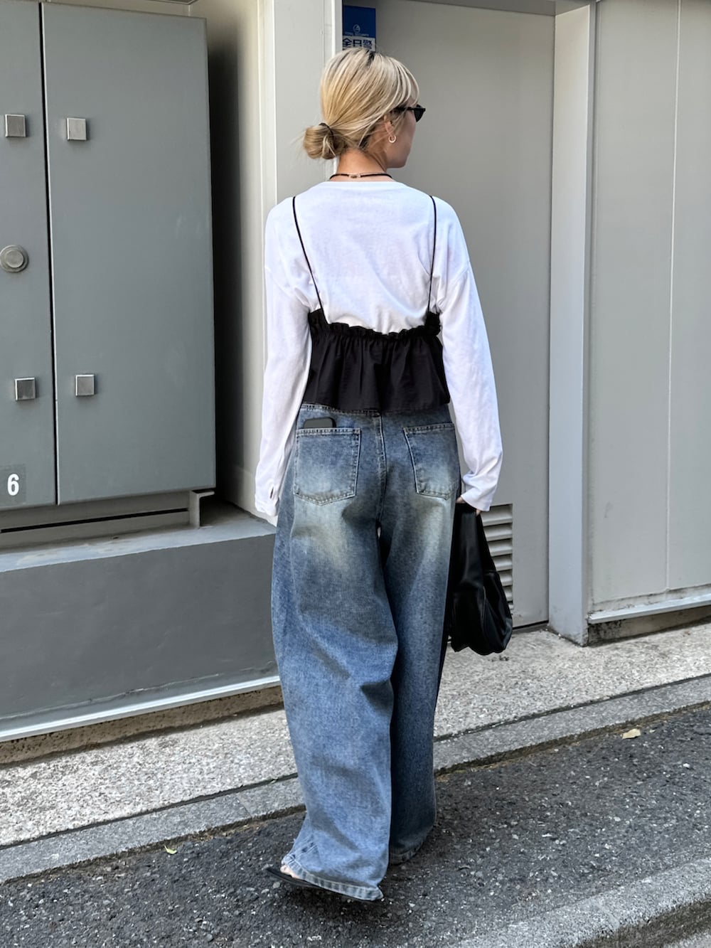 ホワイト系のTシャツ/カットソー、ブラック系のシャツ/ブラウス、ブルー系のデニムパンツを着用したレディースの春コーディネートの2枚目の写真