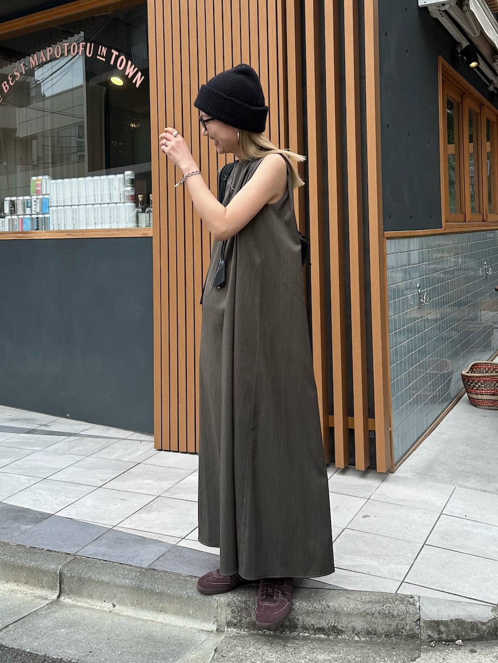 グレー系のワンピース、ブラウン系のスニーカー、ブラック系のバックパック/リュックを着用したレディースの春コーディネートの3枚目の写真