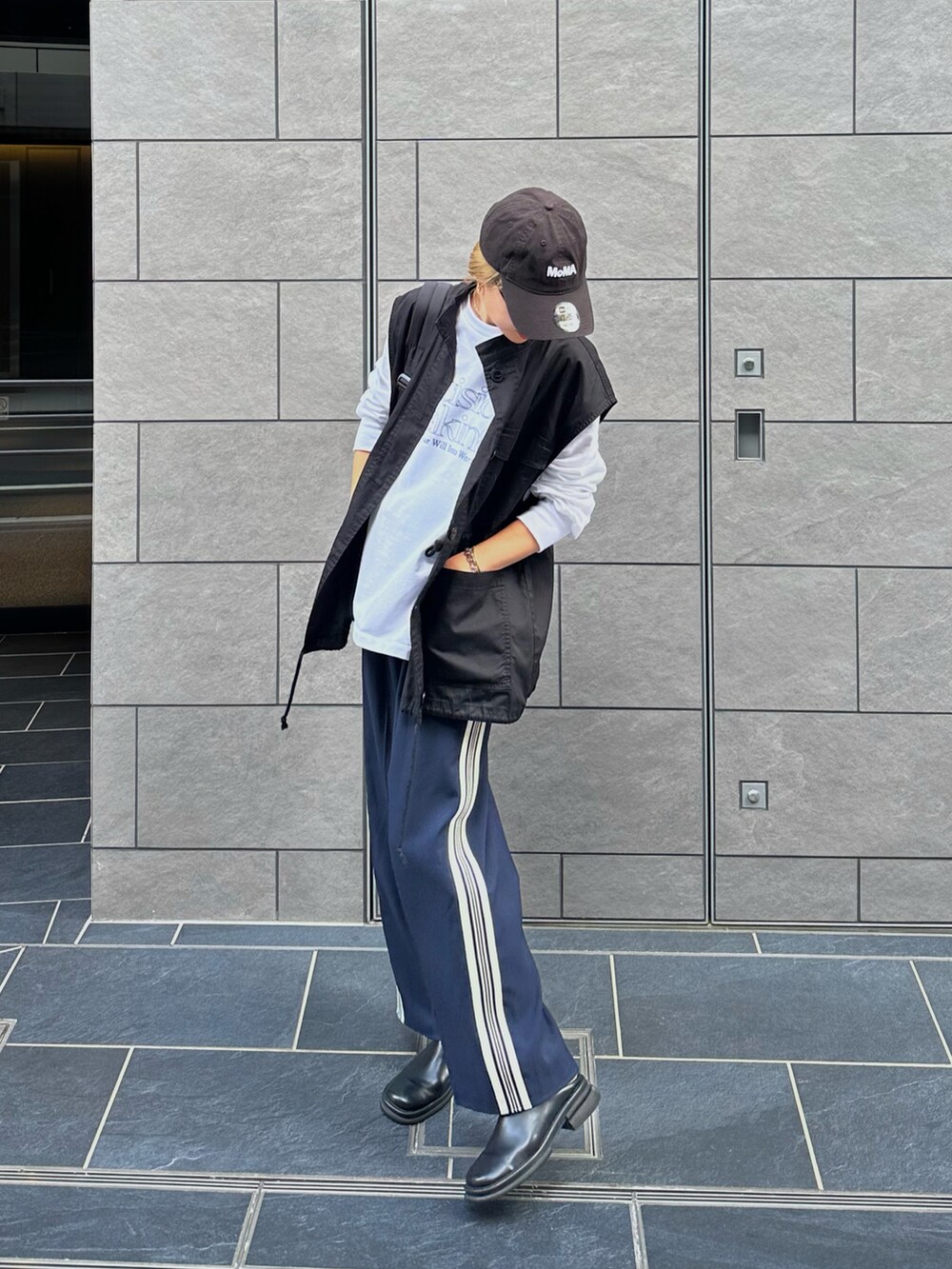 ホワイト系のスウェット、ブラック系のベスト、ブルー系のスラックスを着用したレディースの秋コーディネートの2枚目の写真