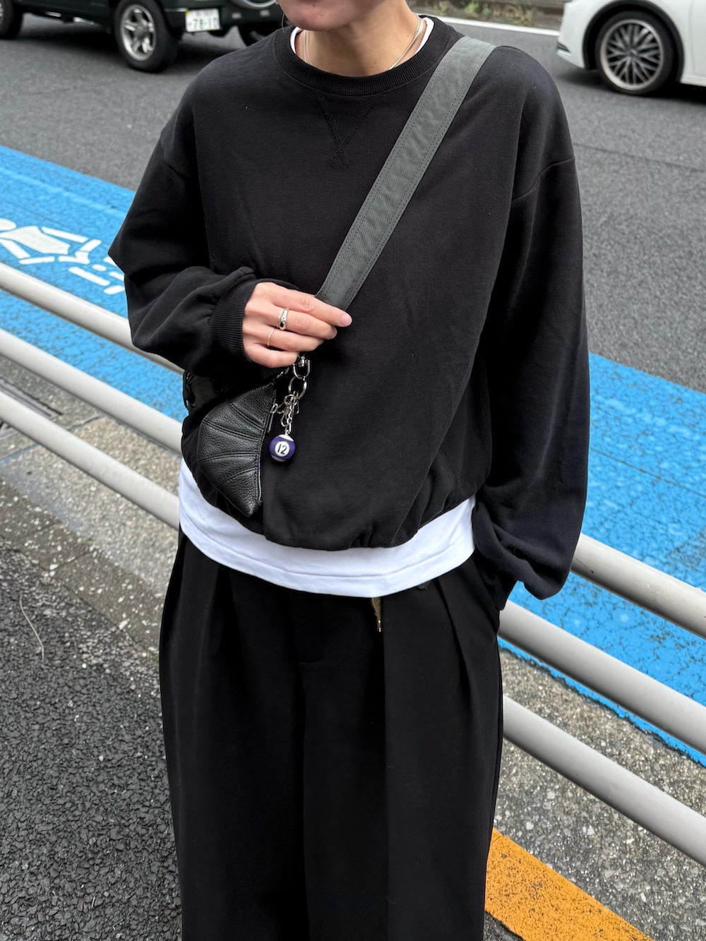 ブラック系のスウェット、ホワイト系のTシャツ/カットソー、ブラック系のスラックスを着用したレディースの秋コーディネートの3枚目の写真