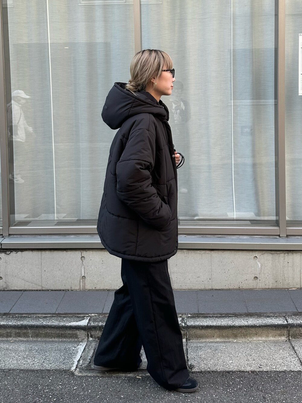 ブラック系のダウンジャケット/コート、ブルー系のニット/セーター、ブラック系のサロペット/オーバーオールを着用したレディースの秋コーディネートの2枚目の写真
