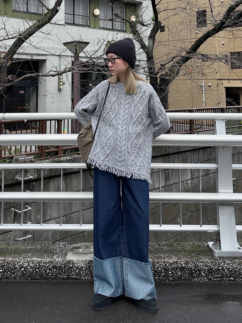 グレー系のニット/セーター、ブルー系のデニムパンツ、グリーン系のバックパック/リュックを着用したレディースの秋コーディネートの5枚目の写真