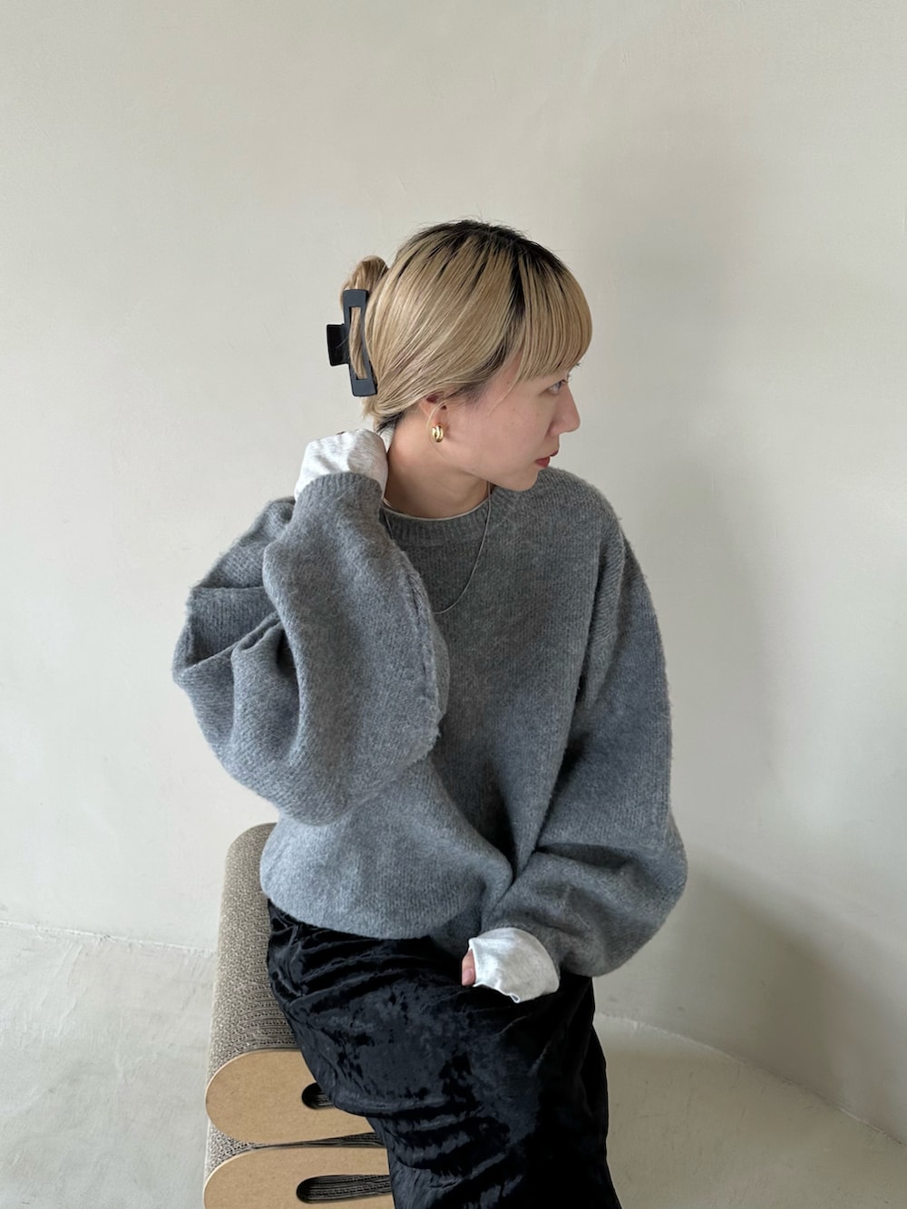 グレー系のニット/セーター、ベージュ系のTシャツ/カットソー、ブラック系のスカートを着用したレディースの秋コーディネートの4枚目の写真