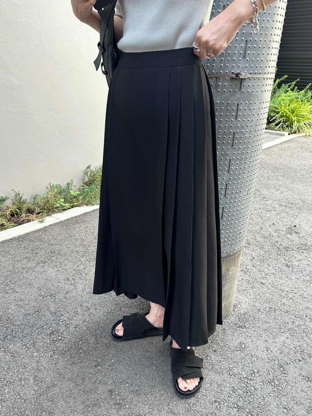 グレー系のニット/セーター、ブラック系のスカート、ブラック系のサンダルを着用したレディースの夏コーディネートの5枚目の写真