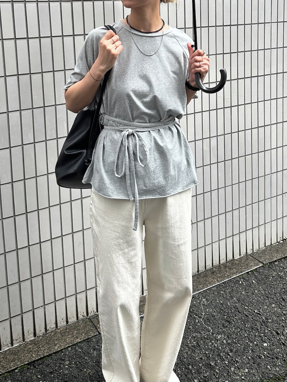 グレー系のTシャツ/カットソー、ホワイト系のデニムパンツ、ブラック系のショルダーバッグを着用したレディースの夏コーディネートの4枚目の写真