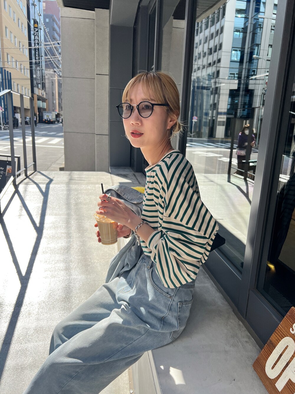 ブルー系のデニムジャケット、ブルー系のデニムパンツ、イエロー系のニット/セーターを着用したレディースの春コーディネートの5枚目の写真