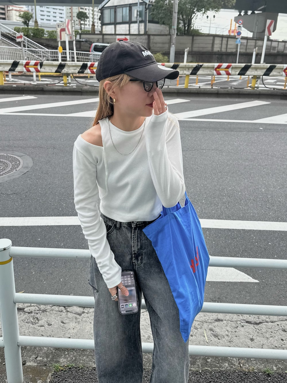 ホワイト系のTシャツ/カットソー、ブラック系のデニムパンツ、ブルー系のトートバッグを着用したレディースの春コーディネートの4枚目の写真