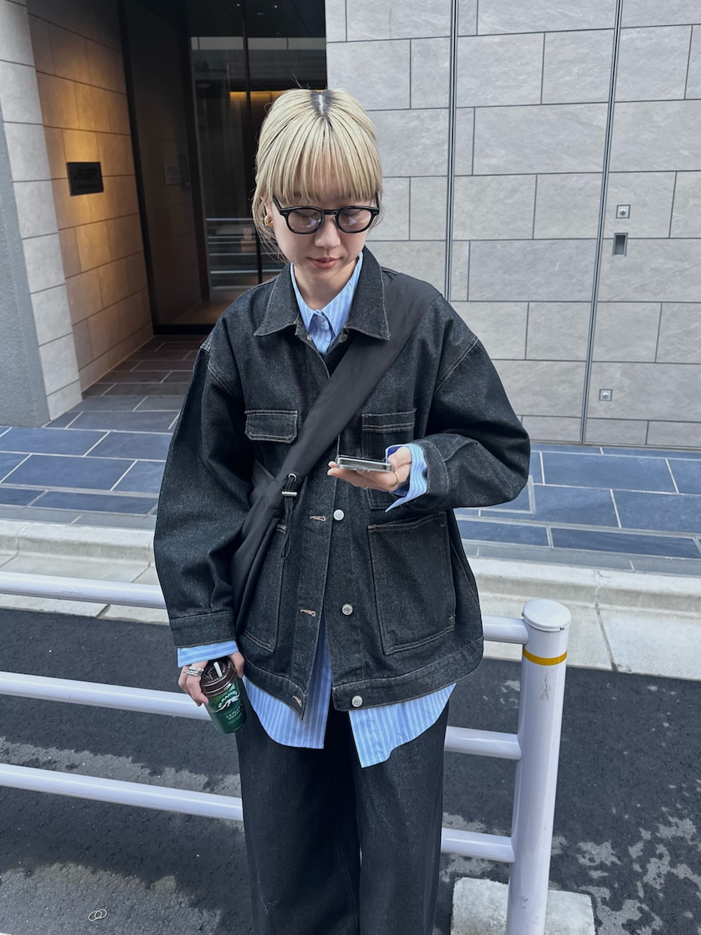 ブラック系のデニムジャケット、ブラック系のデニムパンツ、ブルー系のシャツ/ブラウスを着用したレディースの秋コーディネートの4枚目の写真