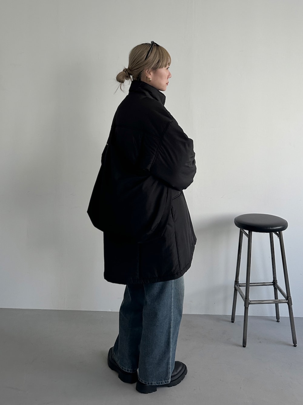 ブラック系のその他アウター、ブルー系のデニムパンツ、ブラック系のショルダーバッグを着用したレディースの冬コーディネートの3枚目の写真