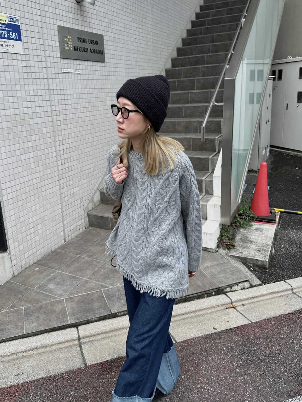 グレー系のニット/セーター、ブルー系のデニムパンツ、グリーン系のバックパック/リュックを着用したレディースの秋コーディネートの4枚目の写真