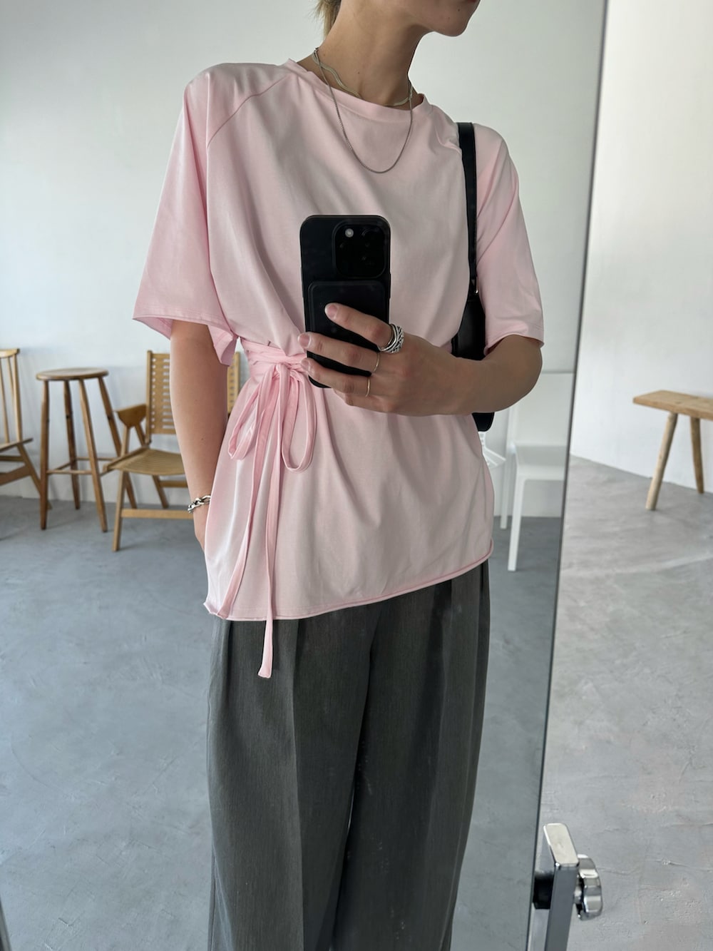 ピンク系のTシャツ/カットソー、グレー系のスラックス、ブラック系のサンダルを着用したレディースの夏コーディネートの3枚目の写真