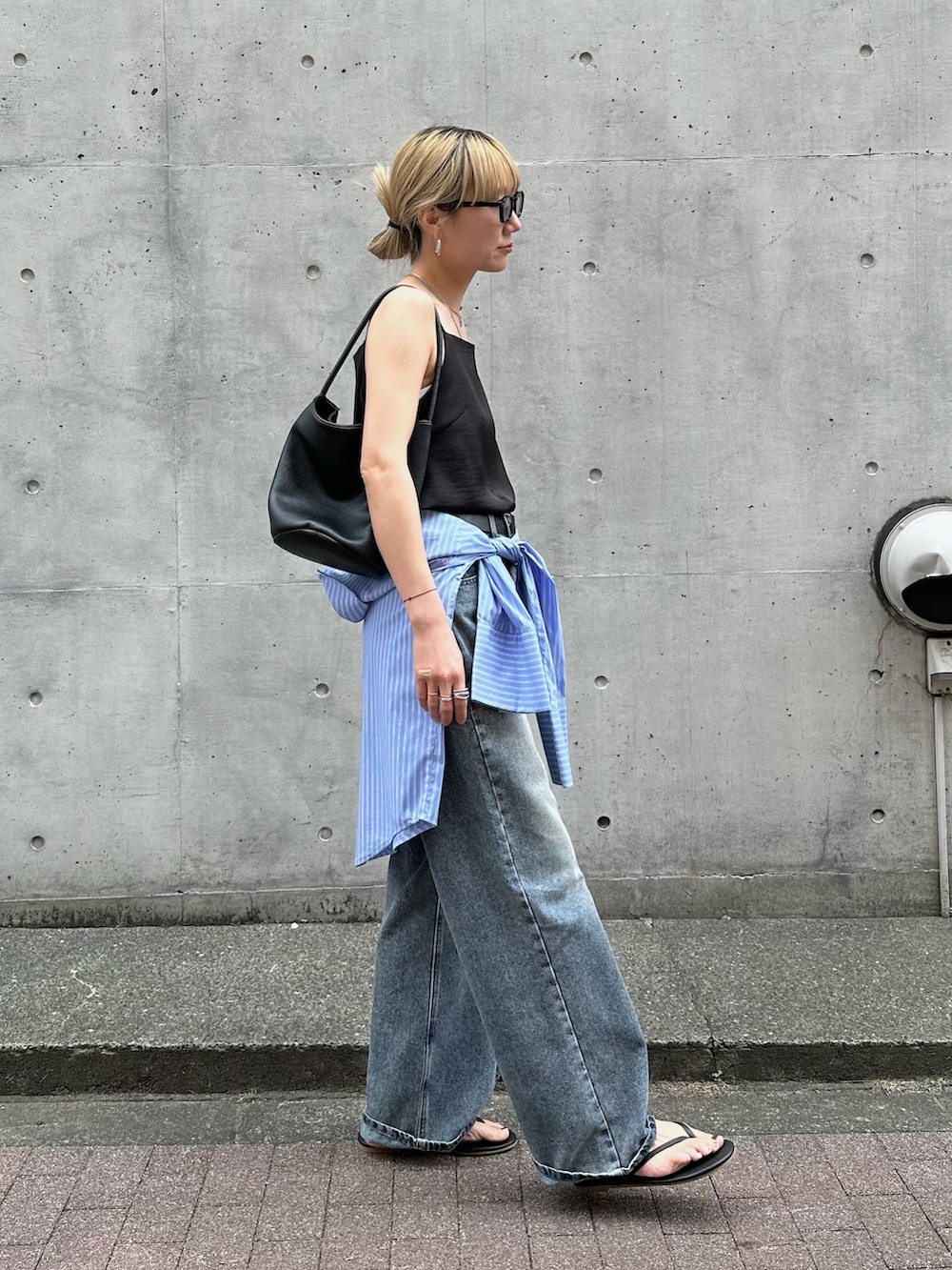 ブラック系のその他トップス、ブルー系のシャツ/ブラウス、ブルー系のデニムパンツを着用したレディースの春コーディネートの4枚目の写真