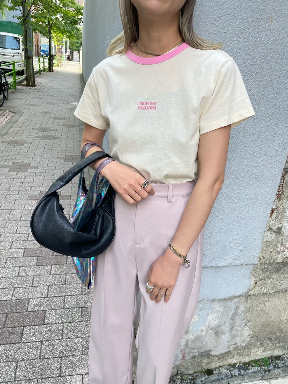 ブラック系のサンダル、ピンク系のTシャツ/カットソー、ピンク系のスラックスを着用したレディースの夏コーディネートの2枚目の写真