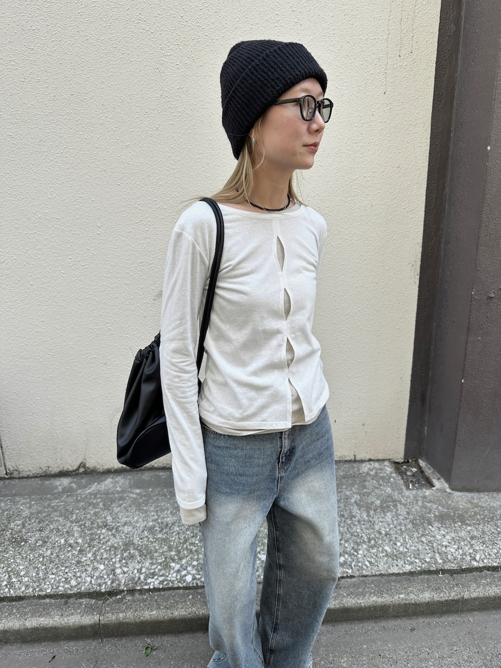 ホワイト系のTシャツ/カットソー、ブルー系のデニムパンツ、ブラック系のショルダーバッグを着用したレディースの春コーディネートの5枚目の写真
