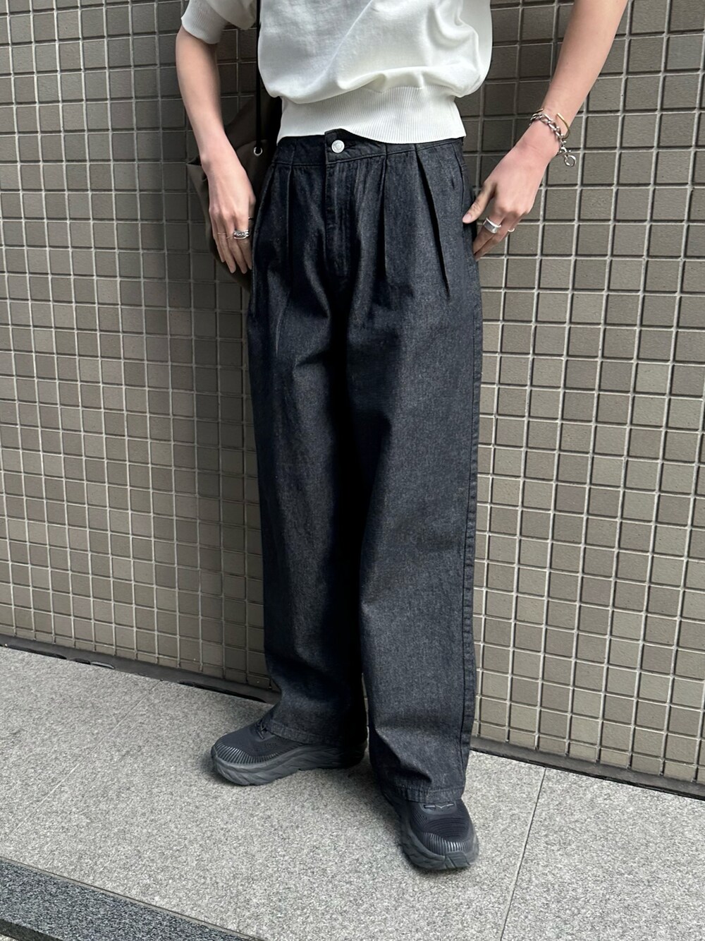 ホワイト系のニット/セーター、ブラック系のデニムパンツ、ブラック系のスニーカーを着用したレディースの春コーディネートの5枚目の写真