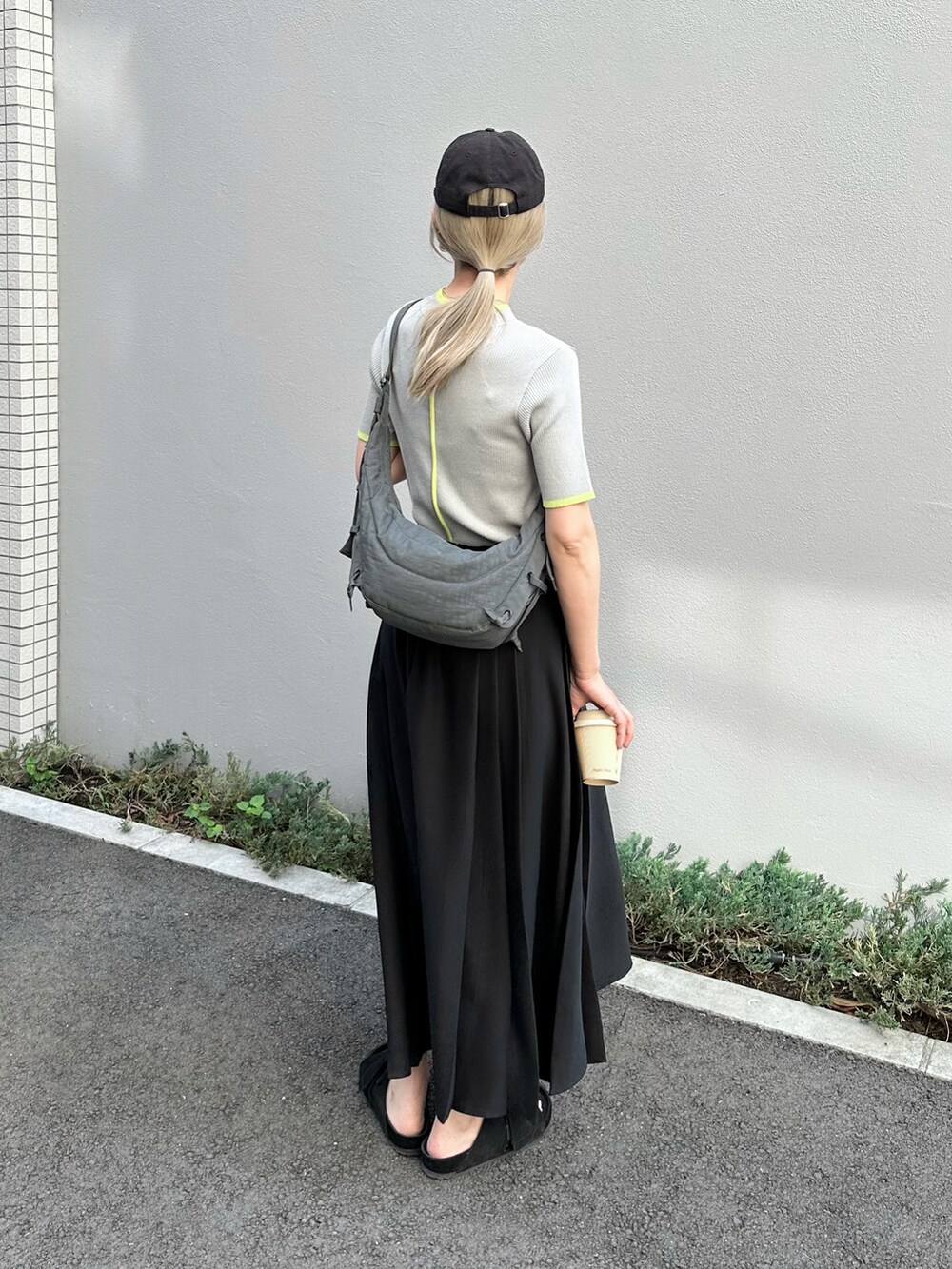 グレー系のニット/セーター、ブラック系のスカート、ブラック系のサンダルを着用したレディースの夏コーディネートの3枚目の写真