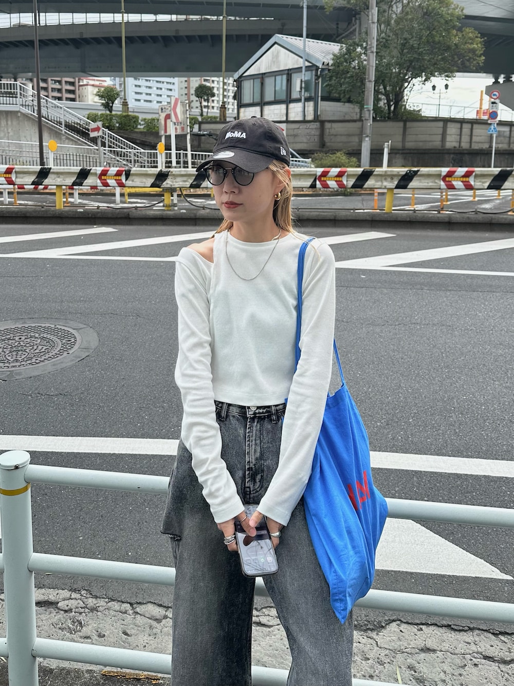 ホワイト系のTシャツ/カットソー、ブラック系のデニムパンツ、ブルー系のトートバッグを着用したレディースの春コーディネートの3枚目の写真