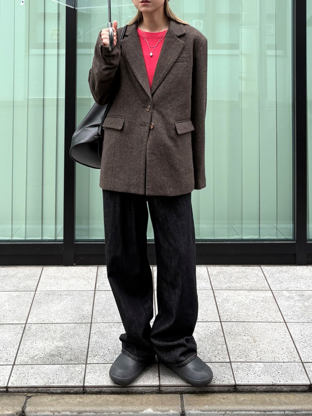 ブラウン系のテーラードジャケット、レッド系のTシャツ/カットソー、ブラック系のデニムパンツを着用したレディースの秋コーディネートの3枚目の写真