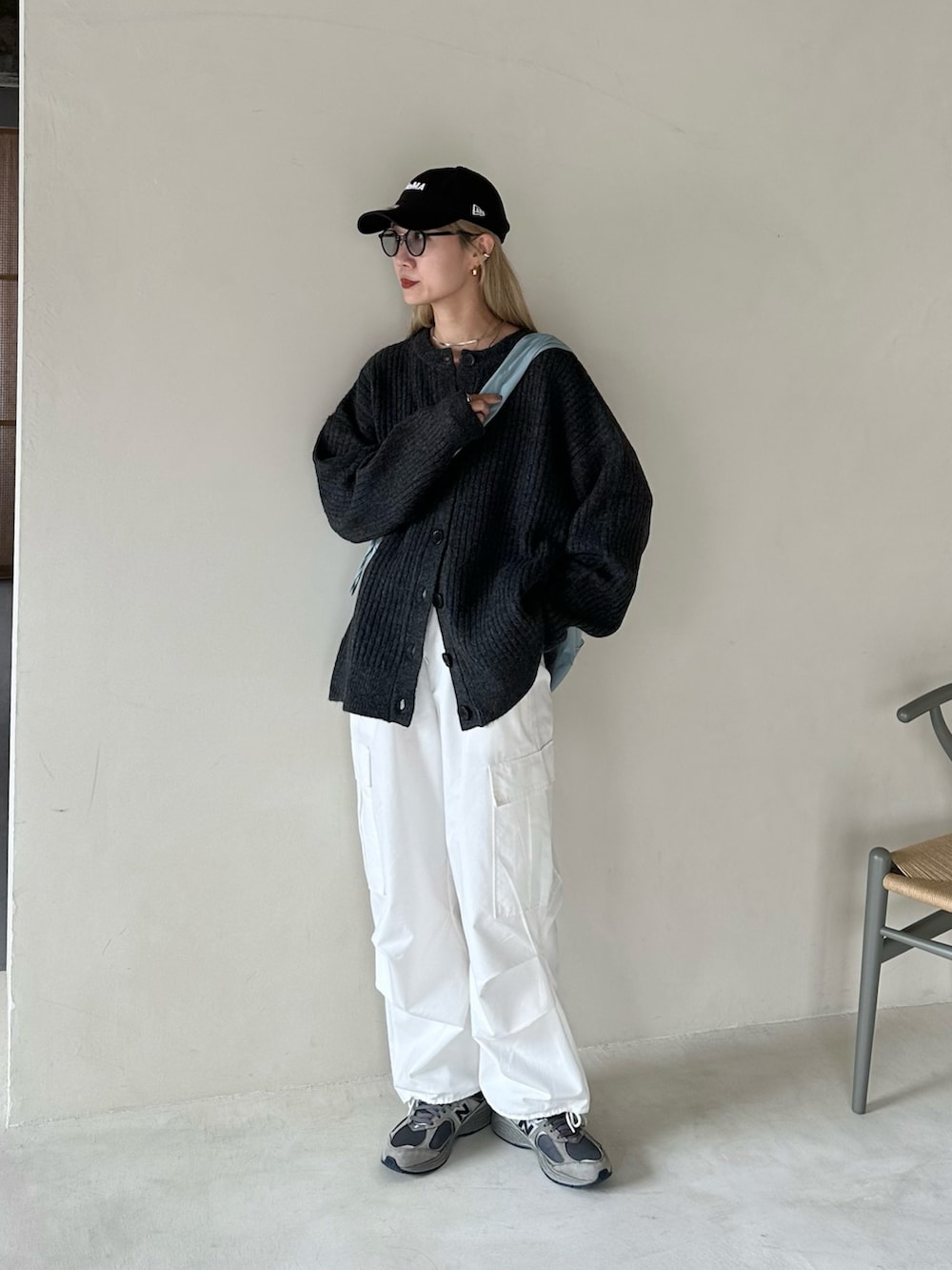 ブラック系のカーディガン/ボレロ、ホワイト系のカーゴパンツ、ブルー系のショルダーバッグを着用したレディースの秋コーディネートの2枚目の写真