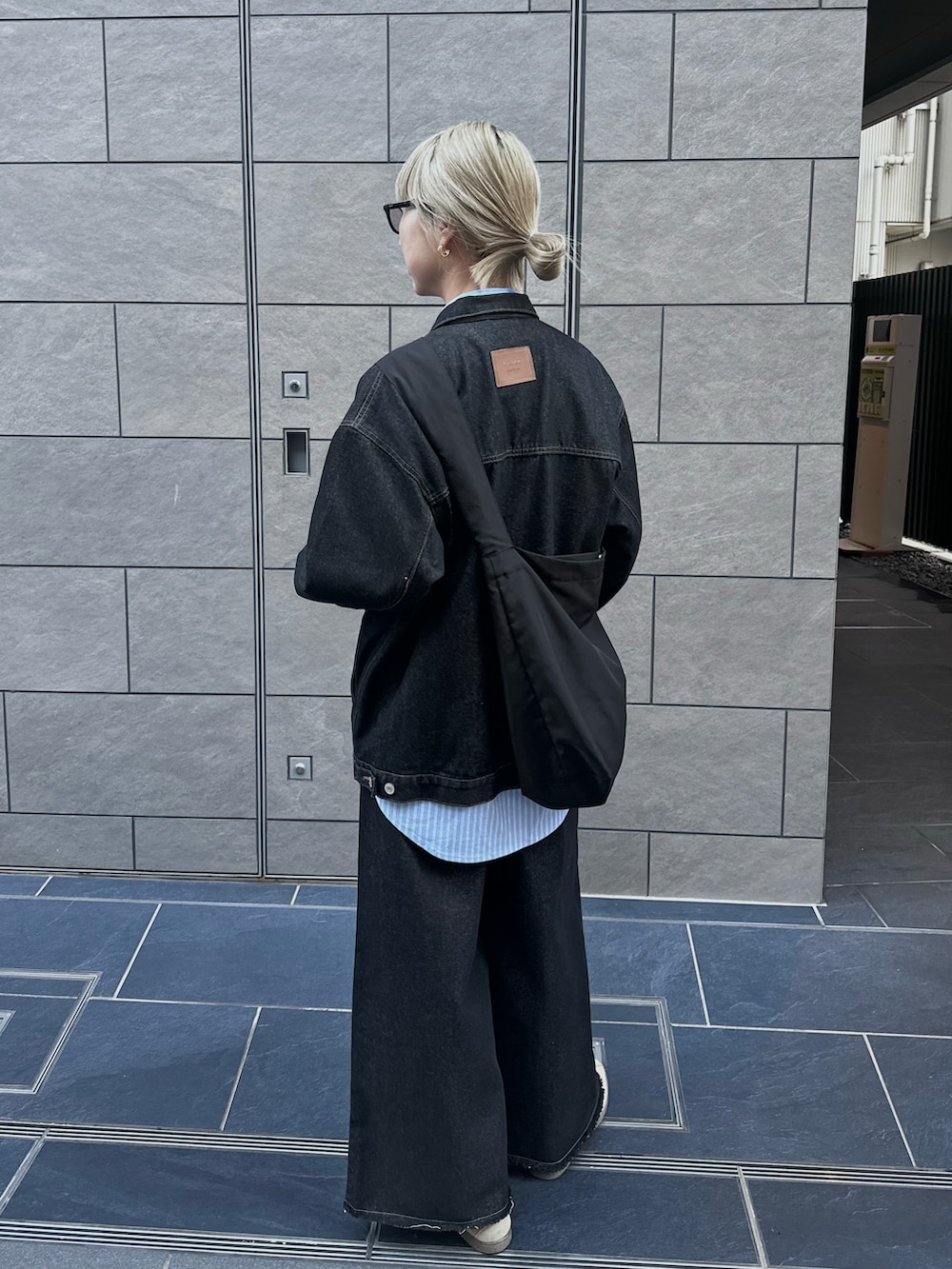 ブラック系のデニムジャケット、ブラック系のデニムパンツ、ブルー系のシャツ/ブラウスを着用したレディースの秋コーディネートの2枚目の写真