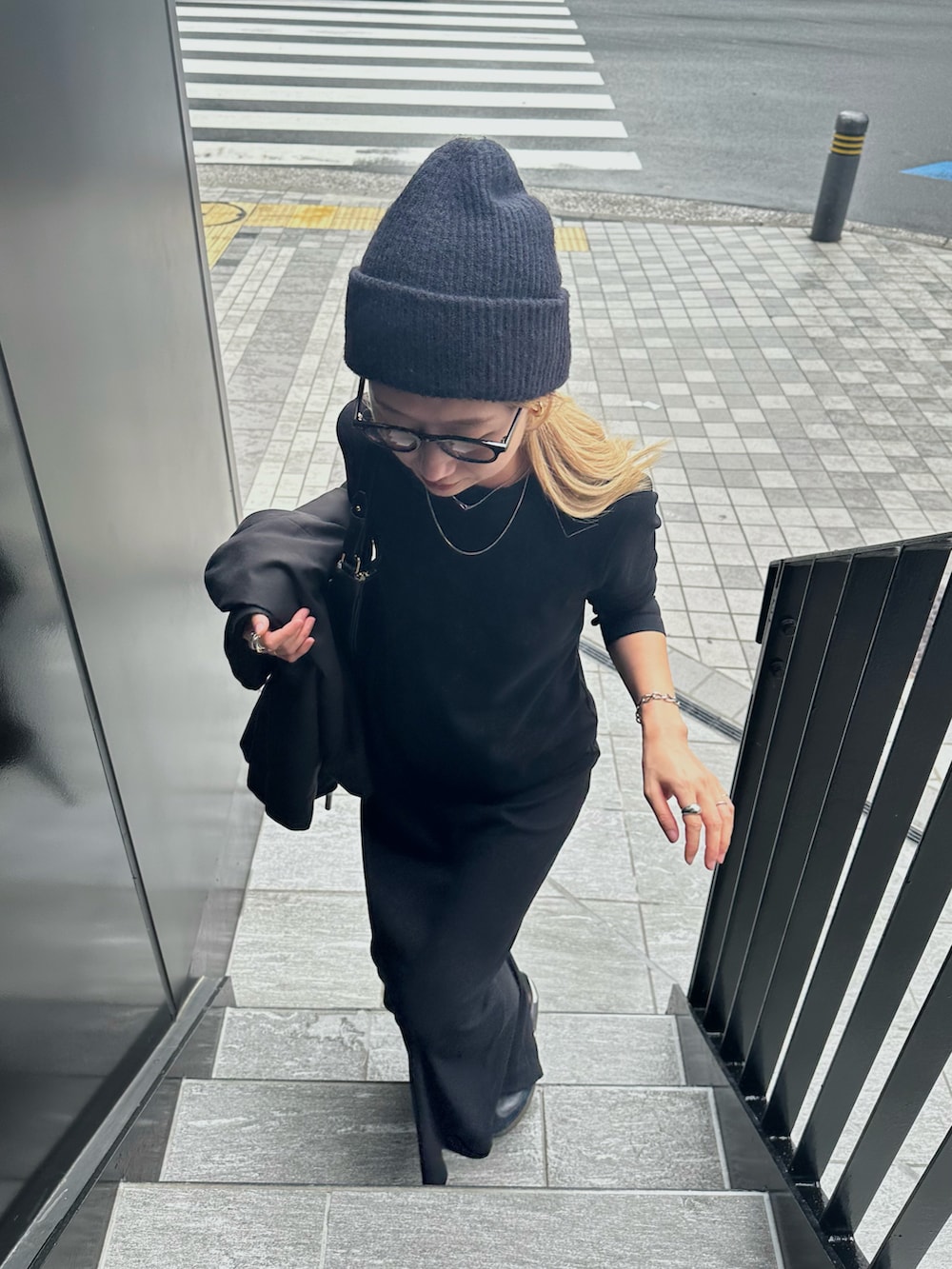 ブラック系のテーラードジャケット、ブラック系のワンピース、ブラック系のスニーカーを着用したレディースの秋コーディネートの3枚目の写真