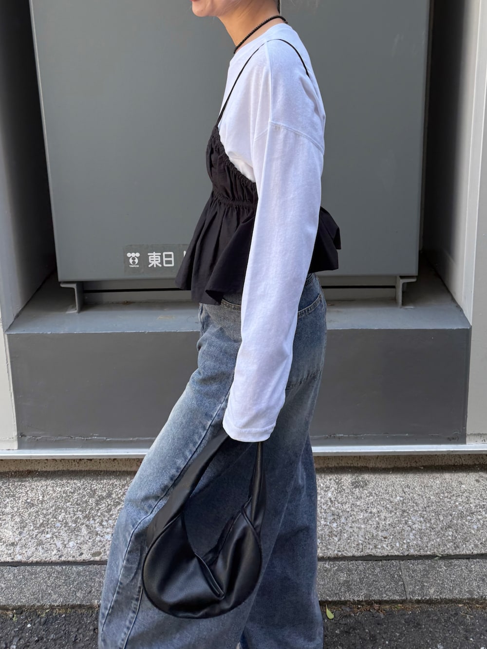 ホワイト系のTシャツ/カットソー、ブラック系のシャツ/ブラウス、ブルー系のデニムパンツを着用したレディースの春コーディネートの5枚目の写真