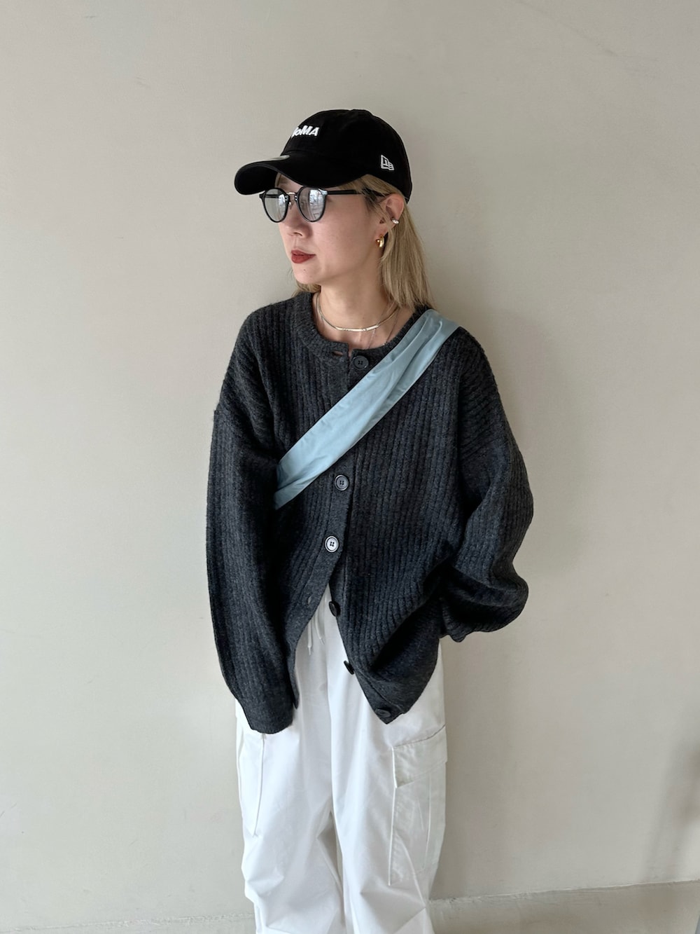 ブラック系のカーディガン/ボレロ、ホワイト系のカーゴパンツ、ブルー系のショルダーバッグを着用したレディースの秋コーディネートの4枚目の写真
