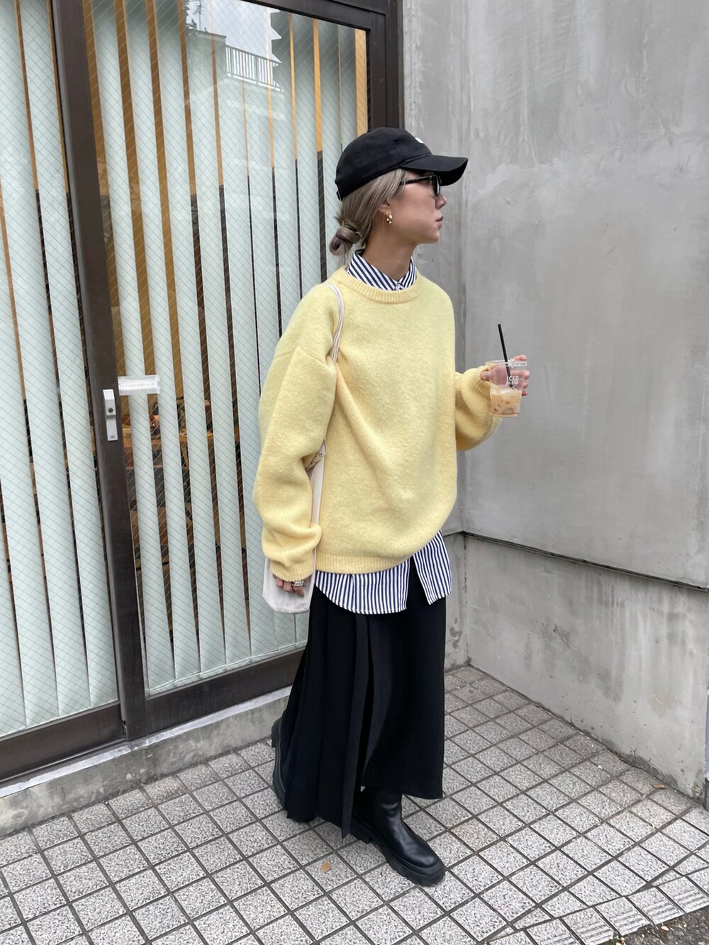 ブラック系のスカート、イエロー系のニット/セーター、ブラック系のシャツ/ブラウスを着用したレディースの冬コーディネートの2枚目の写真