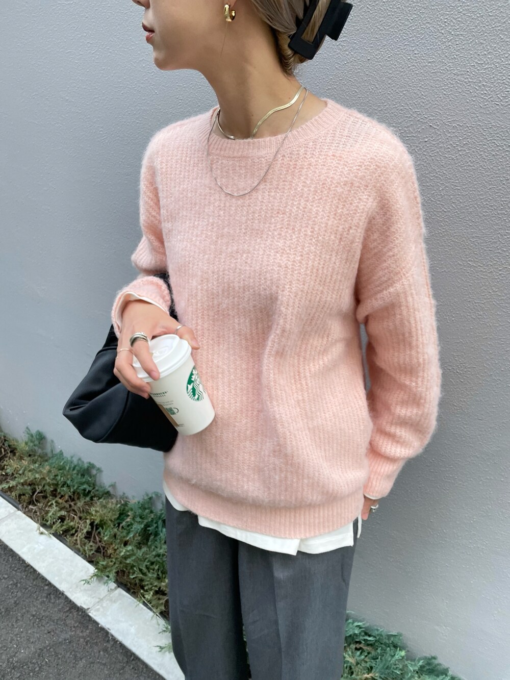 ピンク系のニット/セーター、ホワイト系のTシャツ/カットソー、グレー系のスラックスを着用したレディースの秋コーディネートの2枚目の写真