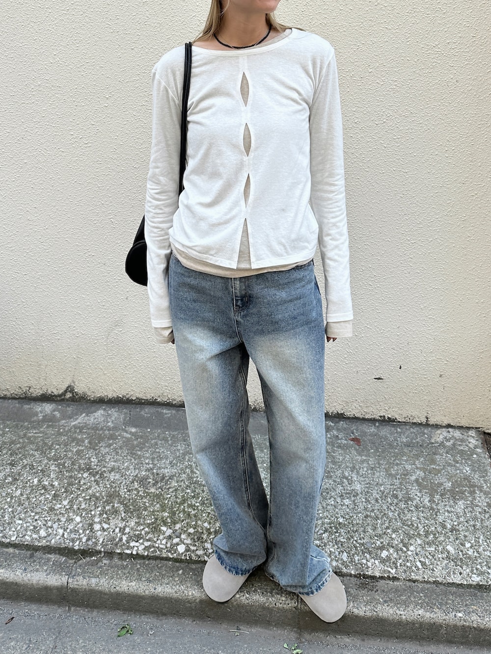 ホワイト系のTシャツ/カットソー、ブルー系のデニムパンツ、ブラック系のショルダーバッグを着用したレディースの春コーディネートの4枚目の写真